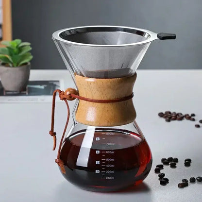 Clear glass chemex coffee kettle with wooden collar and steel filter drip brewer featuring measurement markings