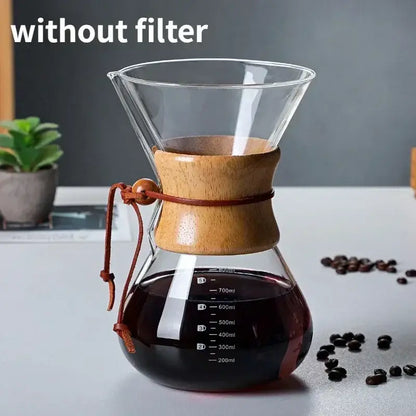 Clear glass chemex coffee kettle with light brown wooden collar and steel filter drip brewer filled with dark coffee