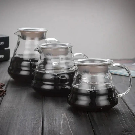 Modern glass coffee pot with stainless steel lid and handle featuring volume indicators for kitchen dining use