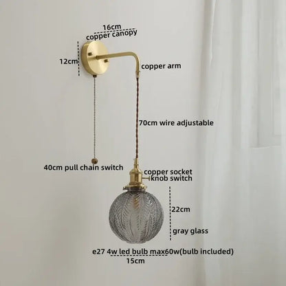 A vintage-style glass copper led wall light with brass copper canopy and adjustable wire featuring gray glass globe