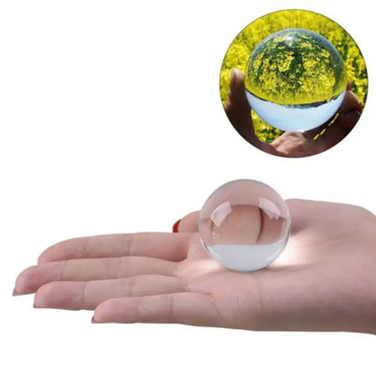 Modern glass crystal ball held in hand displaying its transparent and reflective surface for living room decor use
