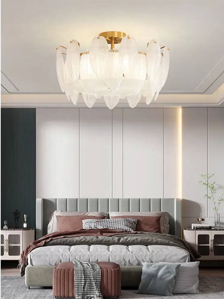 Modern glass feather chandelier featuring white glass feathers and a gold-toned brass pendant light for living rooms