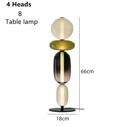 A modern glass floor lamp with four stacked translucent orbs in cream, olive green, and dark gradient hues with led lighting