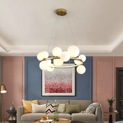 Modern gold-toned glass chandelier lamp with frosted glass globe lights in circular arrangement for kitchen island lighting