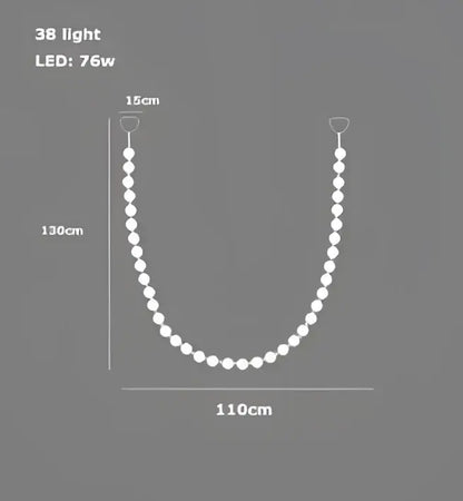 A sleek white led string light with 38 bulbs curving under a modern glass gold pendant light decorbites glass gold