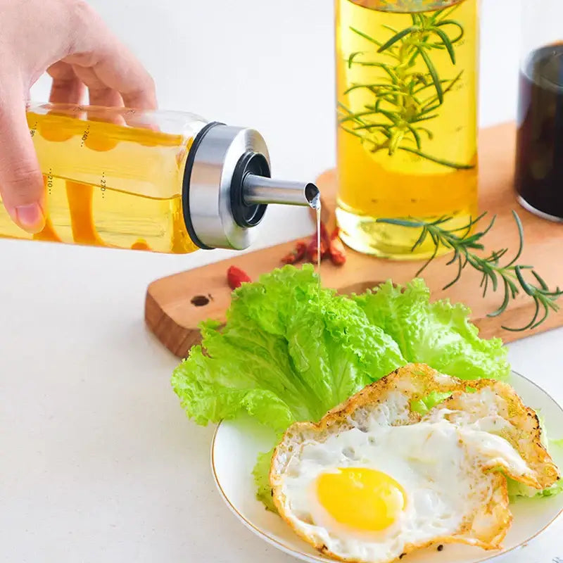 Clear glass seasoning storage bottle with stainless steel spout and black rubber seal filled with golden olive oil