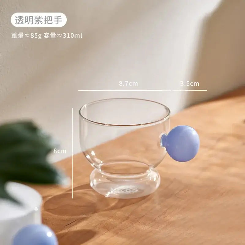 Clear glass coffee mug with a translucent purple glass spherical handle for kitchen and lemon decor use