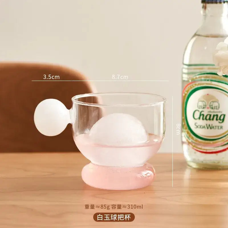 Modern glass spherical handle coffee mug with transparent body white rounded handle and pink base for kitchen decor