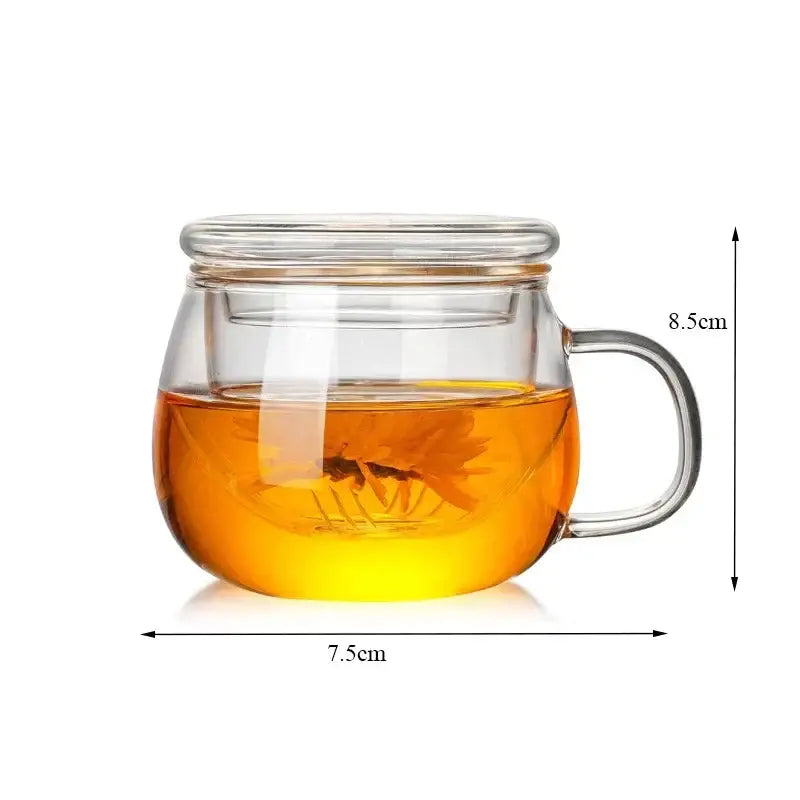 Modern glass tea cup with lid and handle filled with golden-brown glass tea and flower-shaped infuser