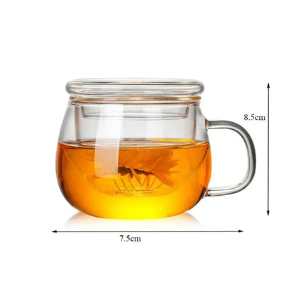Modern glass tea cup with lid and handle filled with golden-brown glass tea and flower-shaped infuser