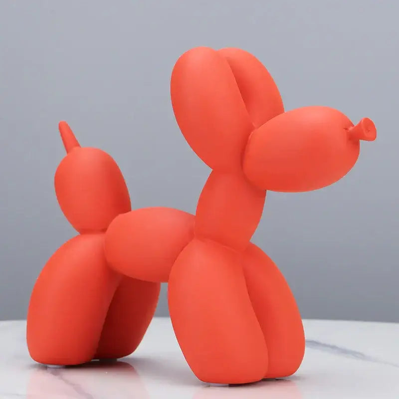 A vibrant orange balloon dog sculpture with a smooth matte finish for modern living room animal decor