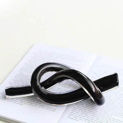 Black glossy enamel pin with silver metal base shaped like elegant infinity knot for decorbites geometric glass decor