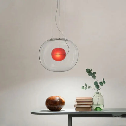 Modern glossy black glass ball pendant light with clear globe and glowing red bulb for dining room decorbites brokis big