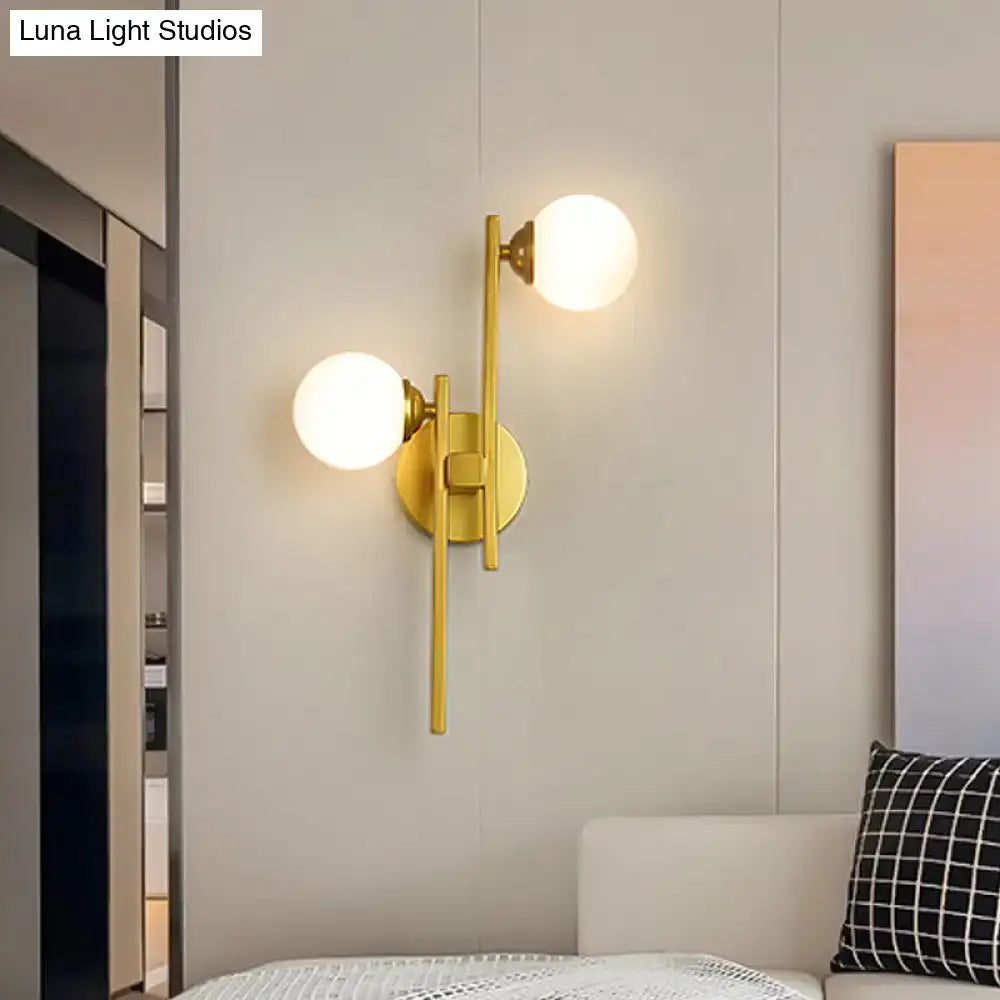 Modern gold wall lamp with two spherical frosted glass shades in gold-toned metal for living room lighting