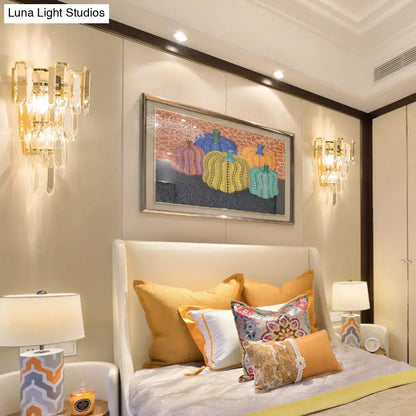 Modern gold 3-headed crystal wall sconce with cascading glass elements in a 15 inch fixture for bedroom lighting