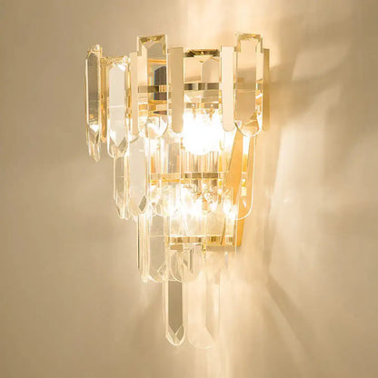 Modern gold 3-headed crystal wall sconce with clear crystal prisms and gold-toned inch fixture for bedroom lighting
