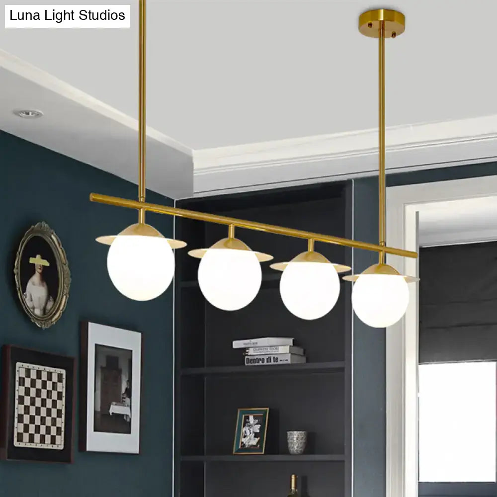 DecorBites gold finished pendant light with four white opal glass globes for contemporary round island lighting