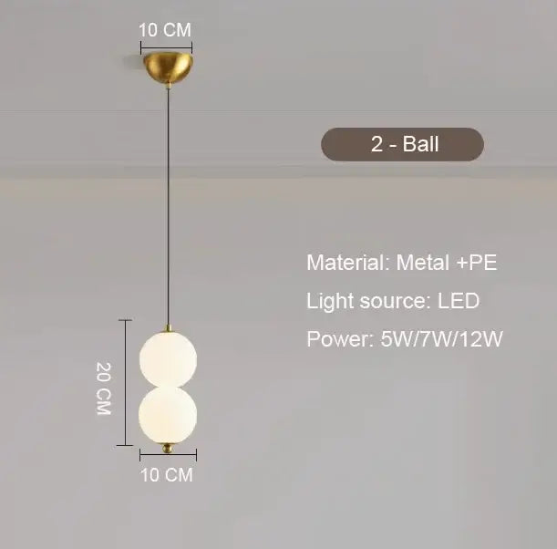 Modern pendant light with plated gold-toned surface and two frosted glass spheres as a dining room focal point