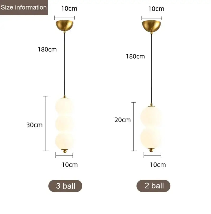 Modern gold pendant light with plated gold-toned surface and frosted glass spheres as a dining room focal point
