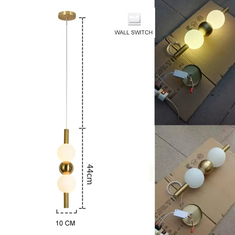 Modern gold pendant light with plated gold-toned surface and three spherical glass bulbs as a dining room focal point