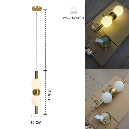 Modern gold pendant light with plated gold-toned surface and three spherical glass bulbs as a dining room focal point