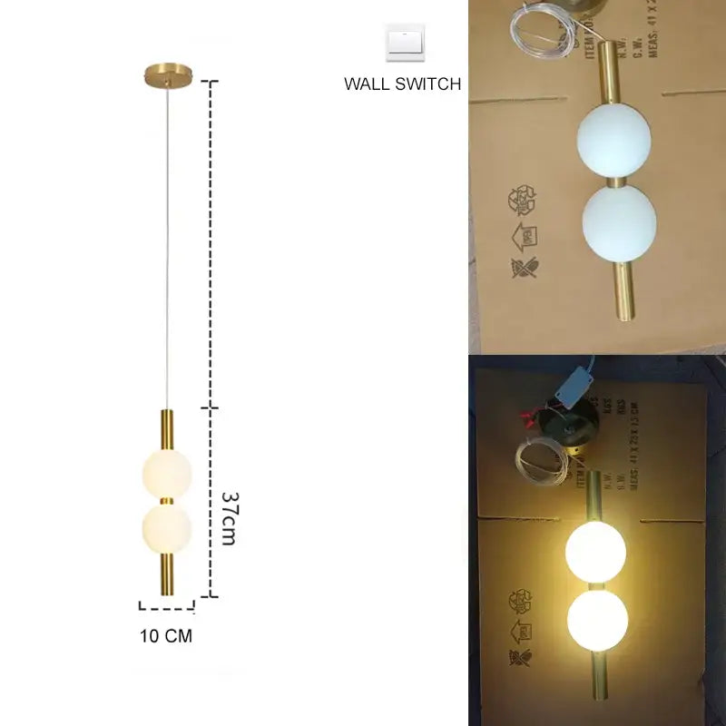 A modern pendant light with two frosted glass spheres and plated gold-toned surface as a dining room focal point