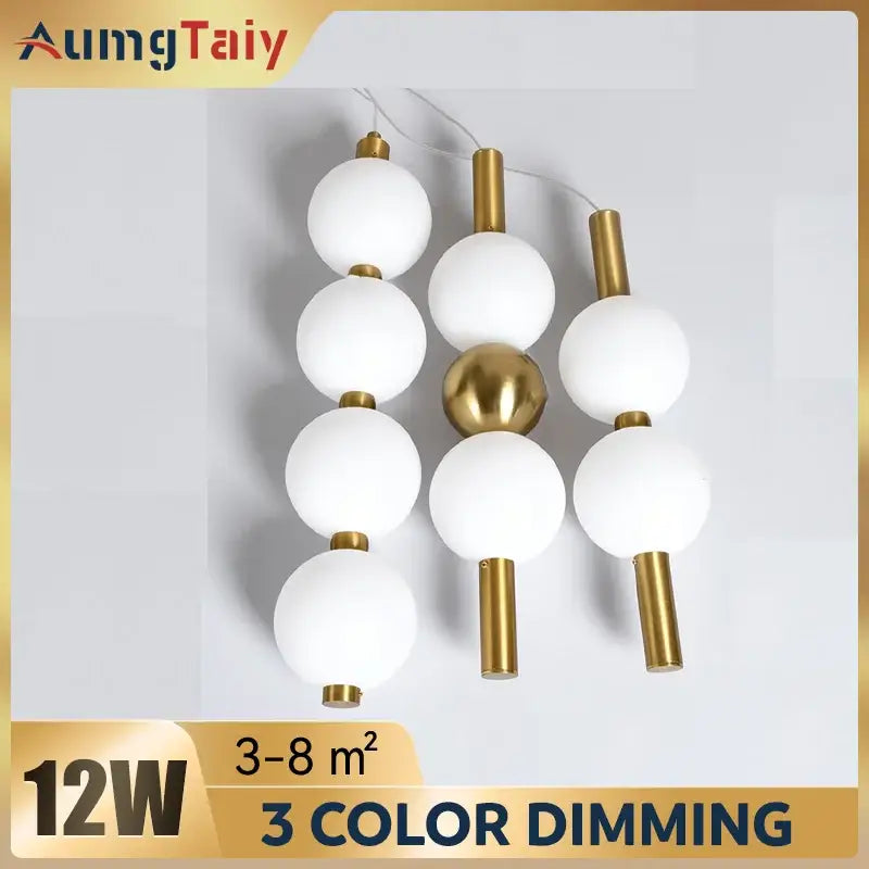 Modern pendant light with white frosted glass spheres and plated gold-toned surface as a dining room focal point