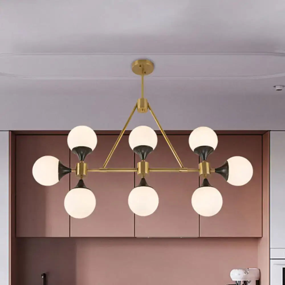 Modern gold decorbites metal chandelier with six frosted glass globe shades and black accents for island lighting
