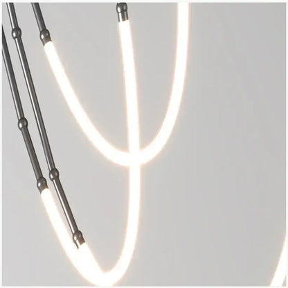Modern black metal pendant light with glowing white led strips forming a curved y-shaped design in brushed nickel and acrylic construction