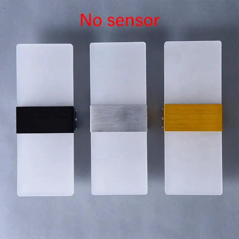 Three modern minimalist acrylic led wall lamps with frosted diffusers and black, brushed silver, and gold accent bars