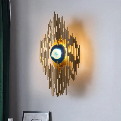 Modern gold agate deco living room wall sconce with radiating vertical bars and central glowing blue orb inch fixture