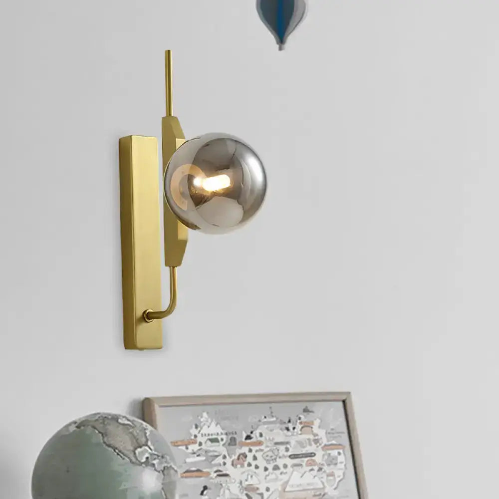 Modern gold and amber glass orb wall light fixture with gold-toned sconce and spherical mirrored bulb, 110v-120v suitable