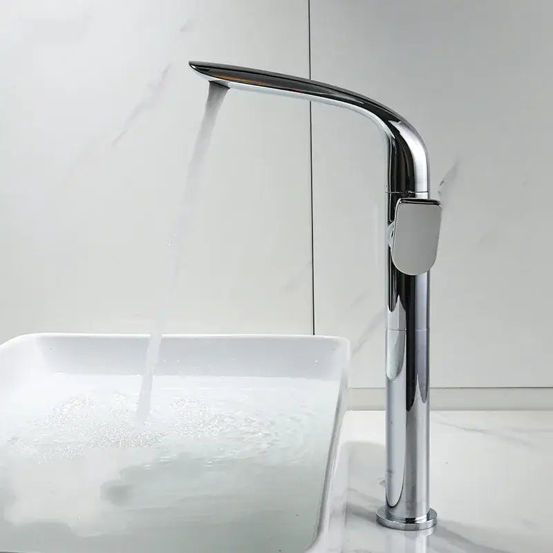 Modern gold and black decorbites basin faucet with chrome high-arc sleek design flowing water into white sink