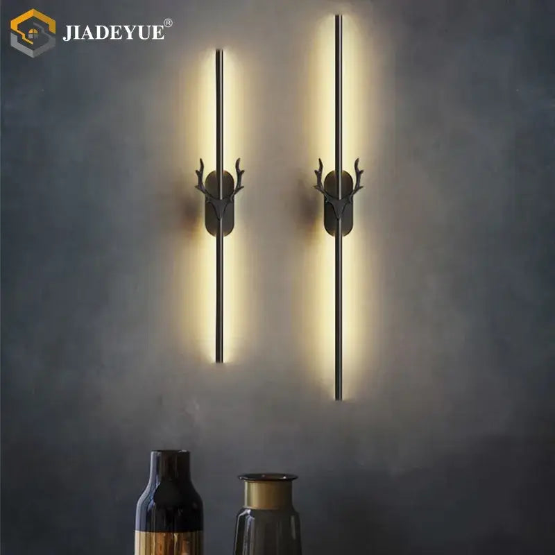 Pair of modern black metal wall lamps with gold decorbites deer horn accents and warm deer horn led lighting
