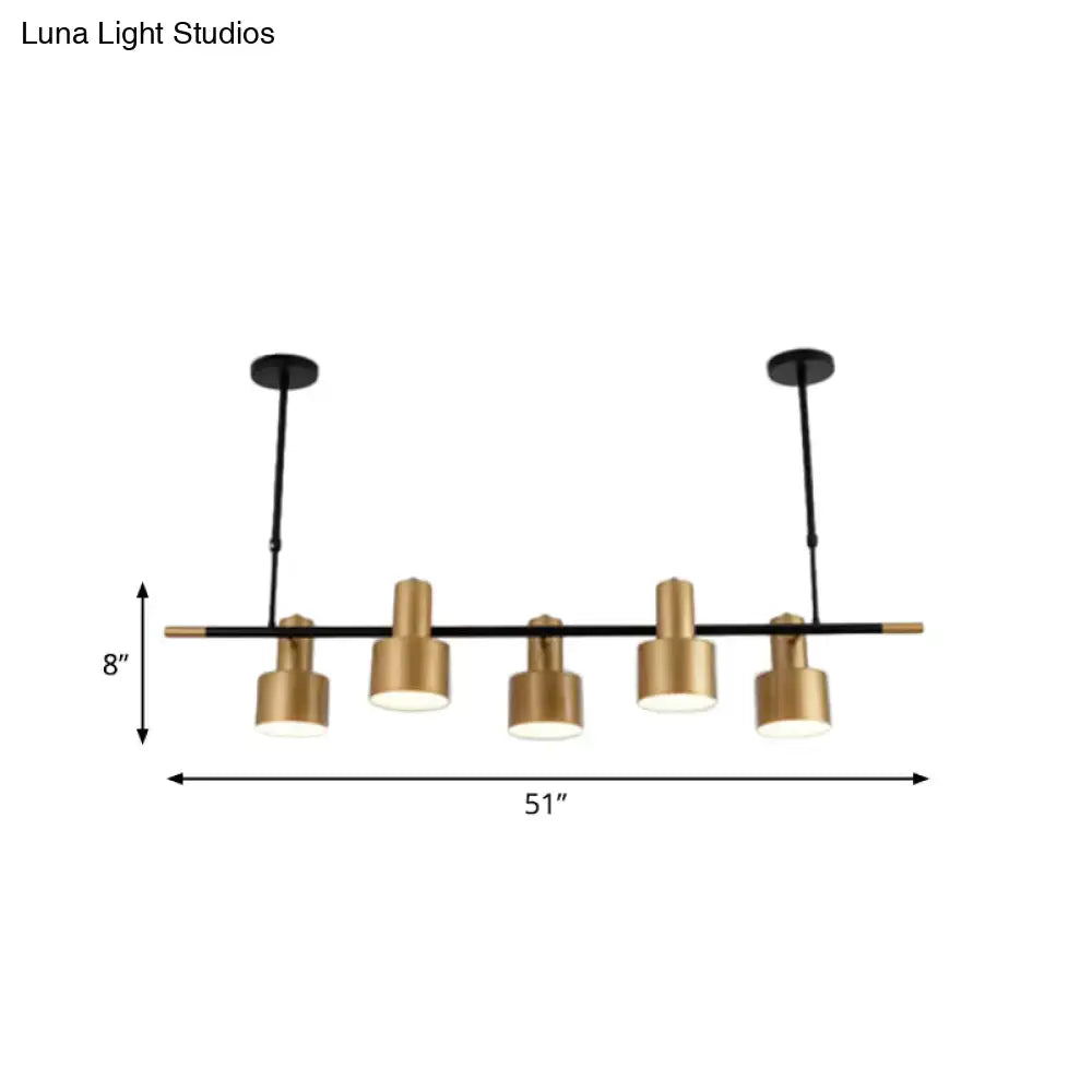 Modern gold and black pendant light with five cylindrical shades for dining room island lighting