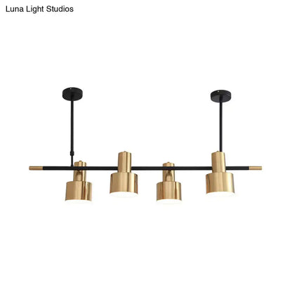 Modern gold and black drum pendant light with cylindrical shades and metal arms for dining room island lighting