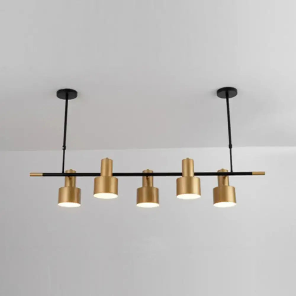 Modern gold and black drum pendant light with sleek metal arms and cylindrical shades for dining room island lighting