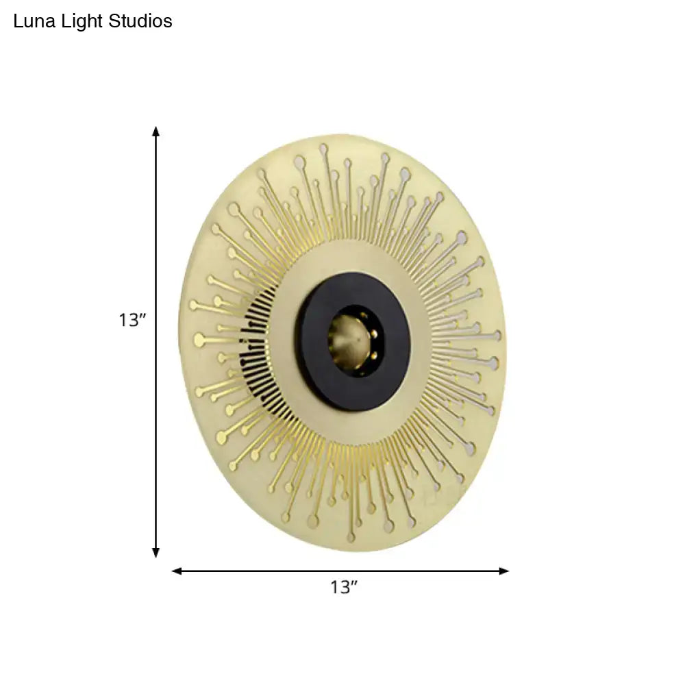 Modern gold and black laser cut disk wall sconce with cream base, gold spikes, and black mounting ring for bedroom lighting