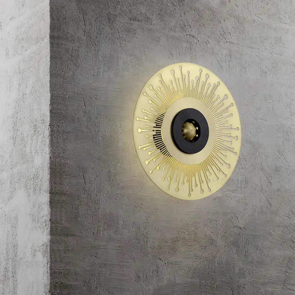 Modern gold and black laser cut disk wall sconce with sunburst design in metal for bedroom lighting