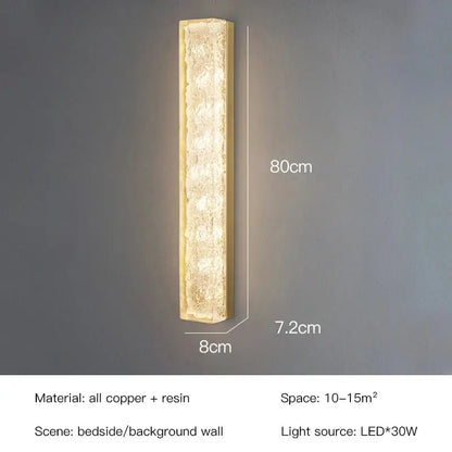 A sleek 80cm tall modern gold and black led bedroom wall lamp with textured resin body framed in copper for decorbites led bedroom