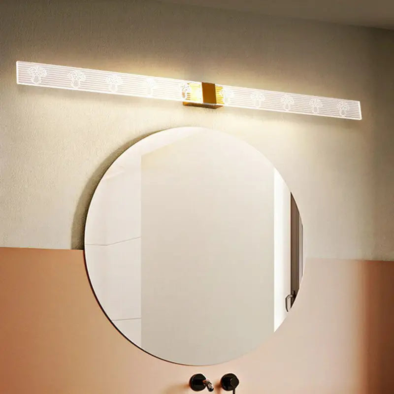 Modern gold and black led vanity sconce light with translucent white diffuser and etched tree patterns for bathroom wall use