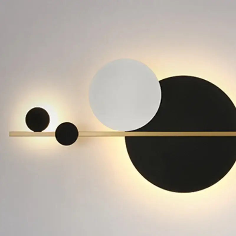 Modern gold and black led wall lamp featuring a sleek horizontal bar with three circular opaque diffusers for bedroom use