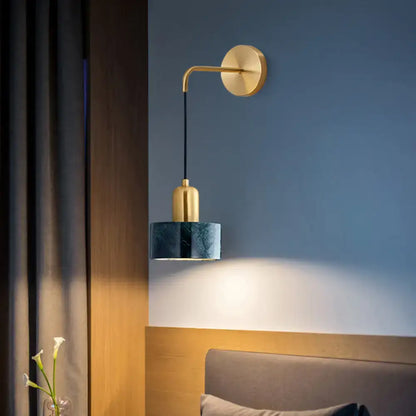 Modern gold and black marble living room light fixture with a gold-toned curved arm and dark teal marble shade