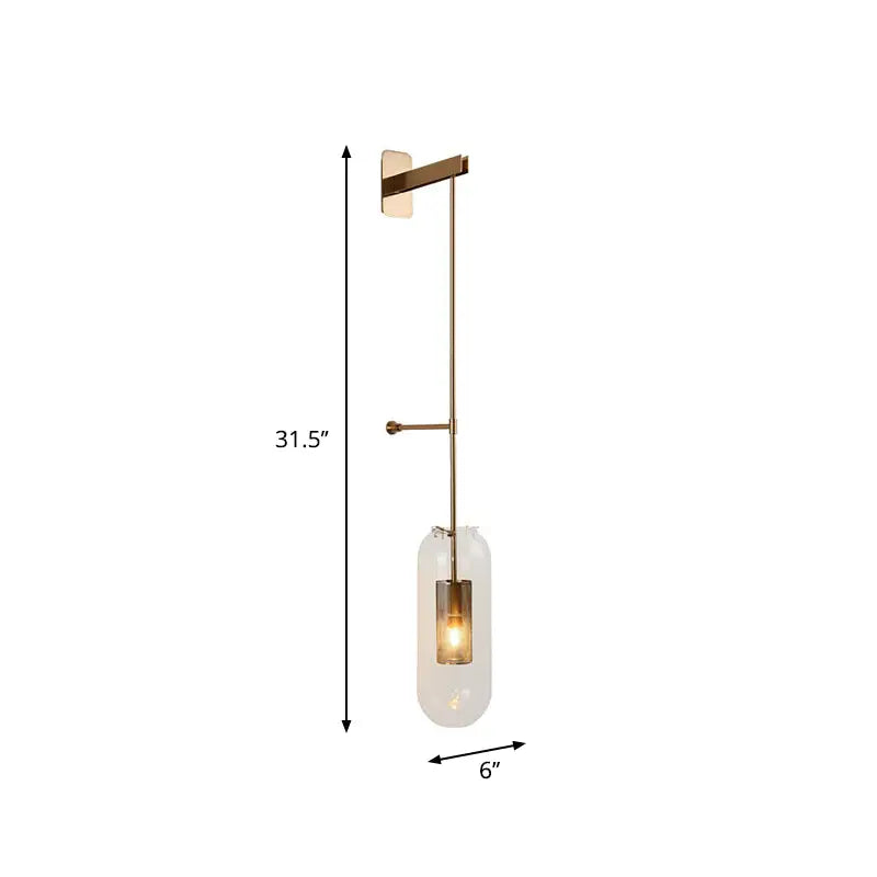 A modern gold and black wall lamp with brass finish and clear glass cylinder for living room illumination