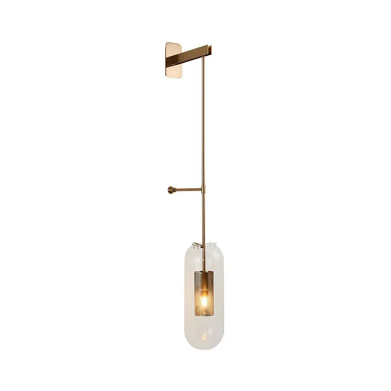 A modern gold and black wall lamp featuring a brass sconce with a clear glass cylinder for living rooms