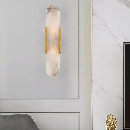 A modern wall lamp featuring a translucent white marble body with polished gold bars for living rooms