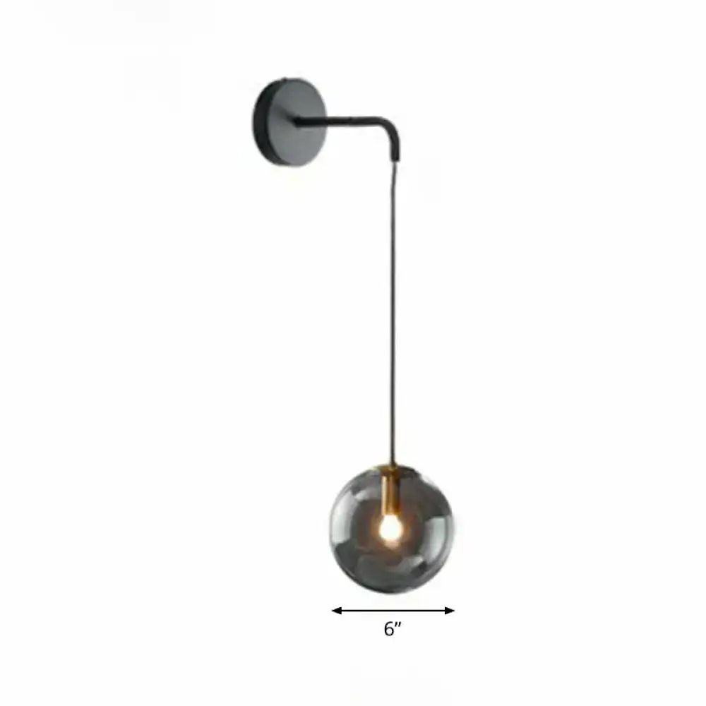 Modern black metal wall sconce with a spherical smoked glass light bulb for living room lighting