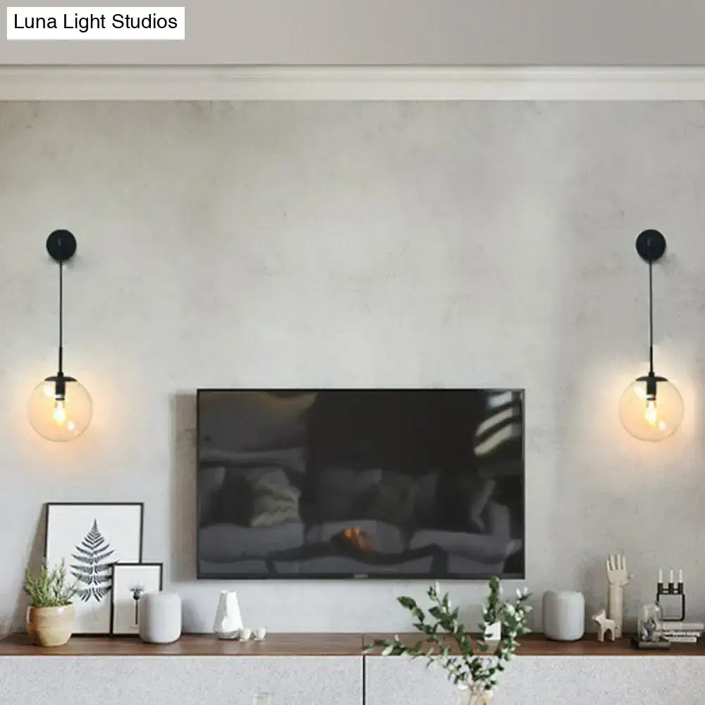 Modern gold and black spherical glass wall light with black pendant light type and clear glass light bulb beside television
