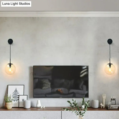 Modern gold and black spherical glass wall light with black pendant light type and clear glass light bulb beside television
