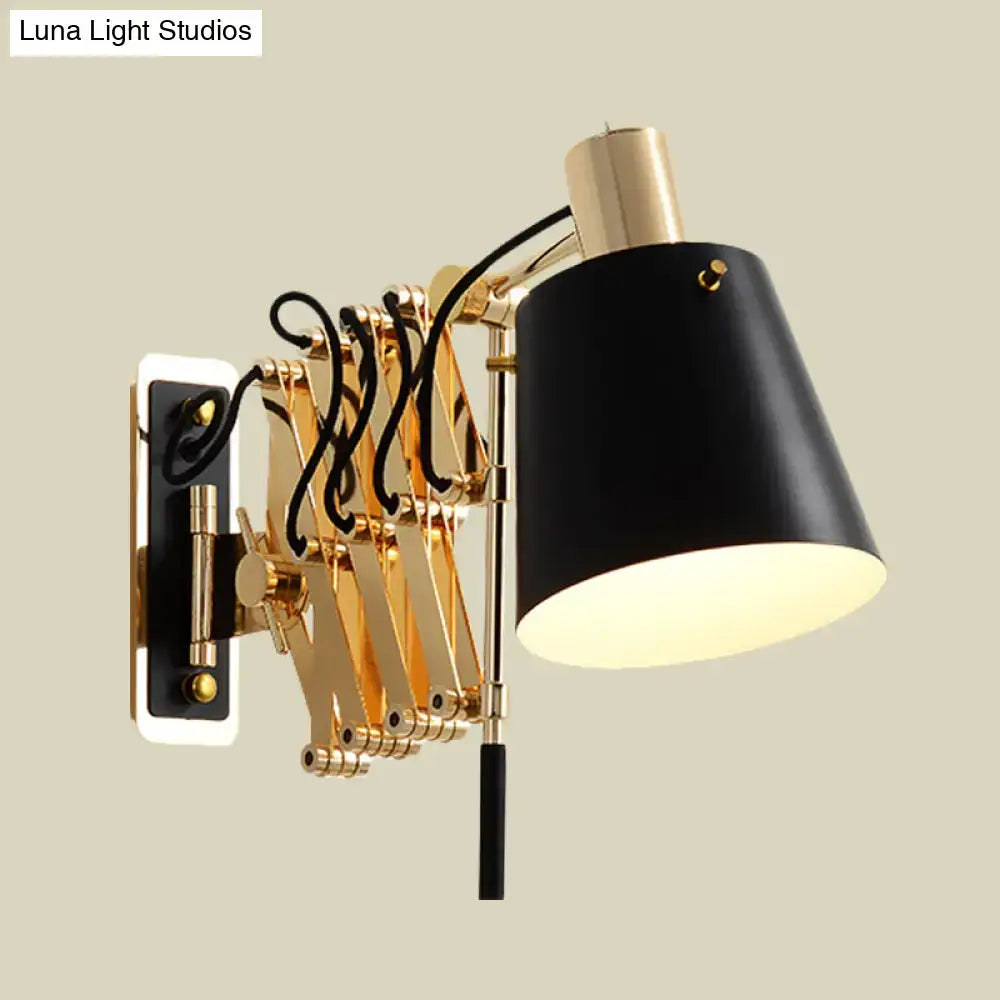 Modern gold and black wall sconce with black matte finish, gold articulated arms, and barrel shade for bedroom lighting